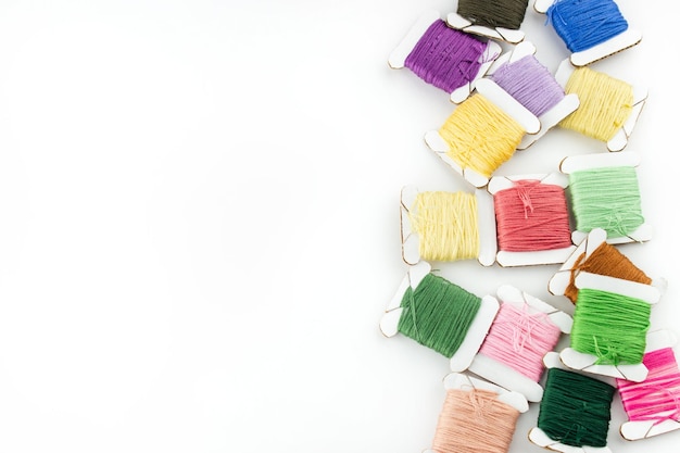 Kolorowe nici i igła ułożone artystycznie